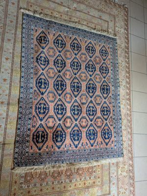 tapis accroché au mur d'une pièce dont le sol est carrelé