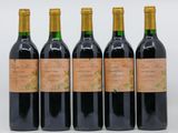 quatre bouteilles de vin sont alignées sur une surface blanche