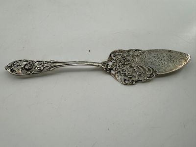a silver spoon with a floral design on it