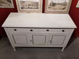 a white cabinet with two doors and two pictures on the wall behind it
