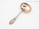 a silver spoon with a spoon handle on a white surface