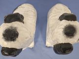 pair of black and white ceramic dog head sculptures on a blue table