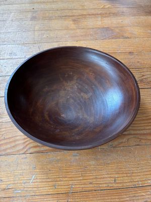 un saladier en bois posé sur une table en bois