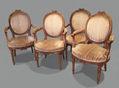 four antique chairs with upholstered arms and a cane back