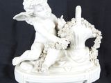 une figurine blanche représentant un garçon avec un panier de fleurs