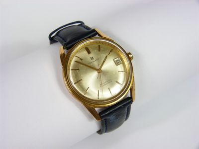 une image d'un gros plan d'une montre-bracelet sur une surface blanche