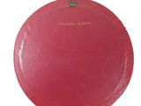 a red purse with a gold handle on a white surface