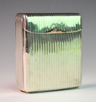 a silver cigarette case sitting on a white surface