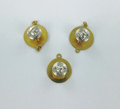trois pendentifs en or et diamants sur un fond blanc