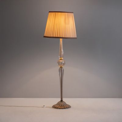 une image représentant une lampe posée sur une table et munie d'un abat-jour