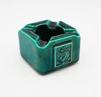 an image of a green ceramic ashtray with a dragon on it