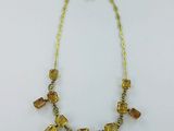 un collier composé de perles de verre jaunes et d'une chaîne en or