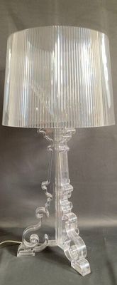 clear glass table lamp with a white shade on top of it