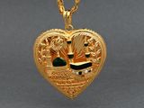 an image of a gold heart shaped locke with a picture of a man and a woman
