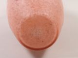 a pink vase sitting on a table with a white background