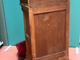 a small wooden cabinet with a door on top of it