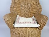a wicker chair with a pillow on top of it