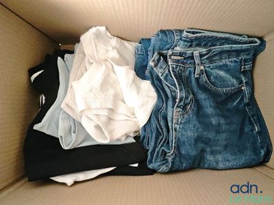 a cardboard box filled with clothes and a pair of jeans