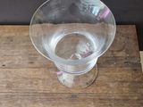 a clear glass sitting on a wooden table next to a wall