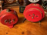 two clocks sitting on a table next to each other