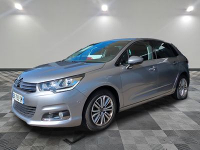 une voiture argentée est garée sur le sol à carreaux d'un garage