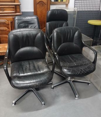 trois fauteuils de bureau en cuir noir dans une pièce, avec une commode en arrière-plan
