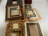 de nombreux cadres de toutes sortes posés sur la table et des tableaux accrochés au mur