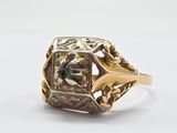 Gros plan sur une bague en or ornée d'une pierre verte