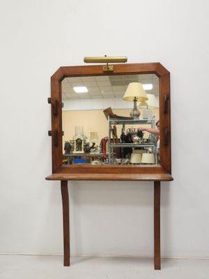 a mirror on a table with a lamp on it