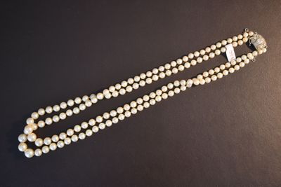 gros plan d'un collier de perles sur une surface noire