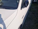 a white car parked in a lot with other cars in the background