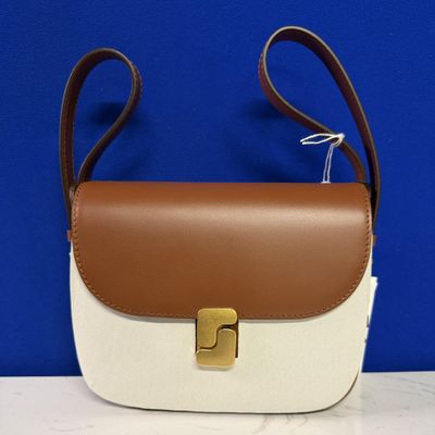 un sac à main blanc et marron posé sur une table