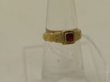 une image représentant une bague en or sertie d'une pierre rouge