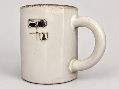 a white coffee cup with a hole in the middle of it