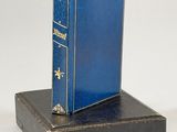 a blue book sitting on top of a black box
