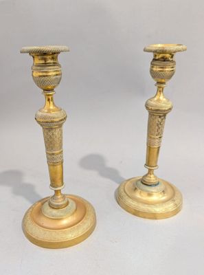 paire de chandeliers anciens en laiton sur piédestal sur fond blanc