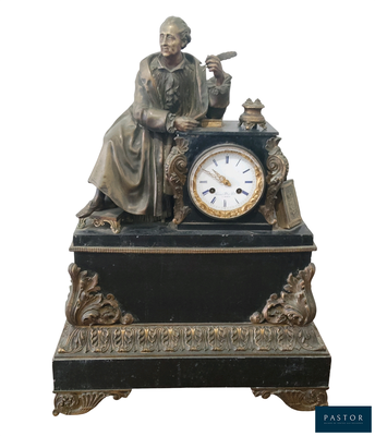 une statue d'un homme assis au sommet d'une horloge