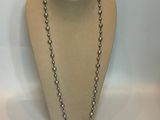 silver beaded necklace with a cross charm on a mannequin