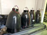 four large black vases sitting on top of a conveyor belt