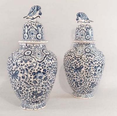 une paire de vases bleus et blancs sur lesquels sont posés des oiseaux