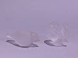 two white fish shaped dishes sitting on a white surface