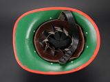 an old green and red helmet on a black background