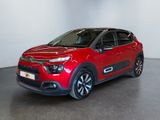 a red citrole is parked in a large room