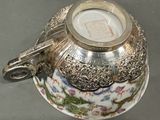 a silver vase with a dragon on it on a table