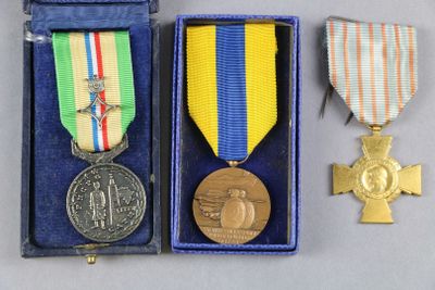 deux médailles et une croix se trouvent dans une boîte bleue