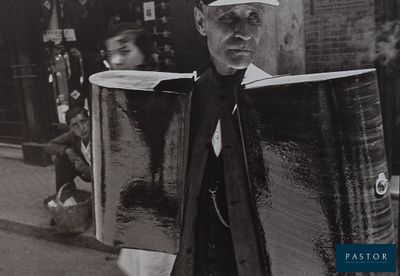 photographie en noir et blanc d'un homme portant un gros bagage