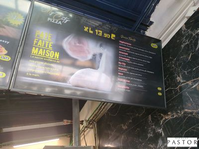 un menu accroché au mur d'un restaurant, sur lequel figure une photo