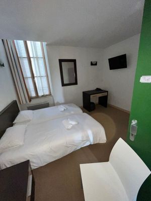 une photo d'une chambre avec un lit et un bureau