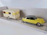 a yellow car and a trailer on a clear shelf