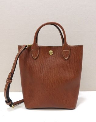 un petit sac à main marron posé sur une surface blanche